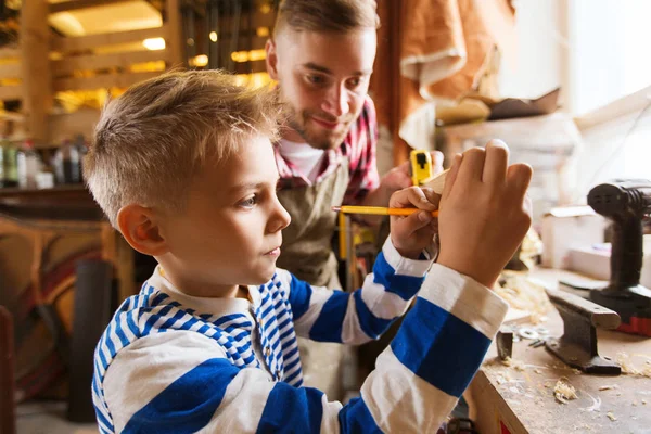 Otec a syn s pravítka změřte dřevo na workshop — Stock fotografie