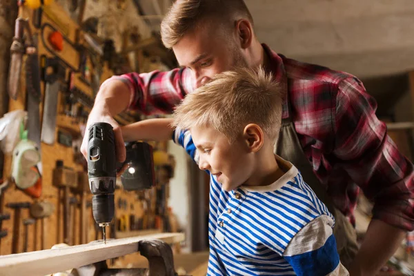 Padre e hijo con taladro trabajando en el taller —  Fotos de Stock