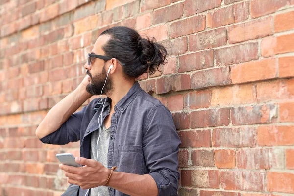 Homem com fones de ouvido e smartphone na rua — Fotografia de Stock