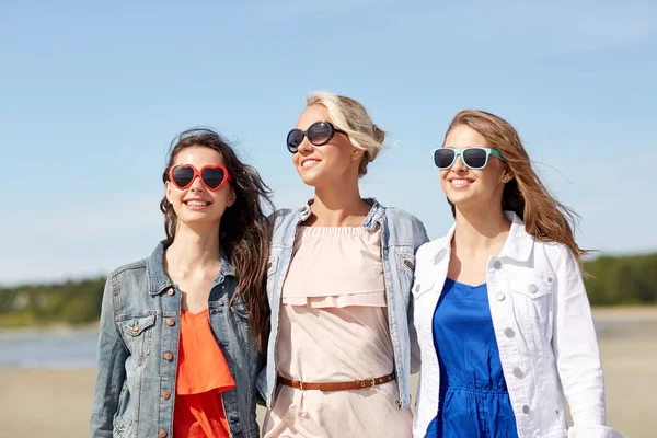Group of smiling women in sunglasses on beach — Stock Photo, Image
