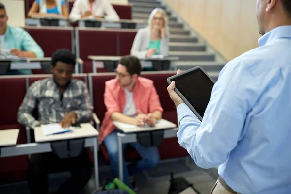 Teacher with tablet pc and students at lecture — Stock Photo, Image