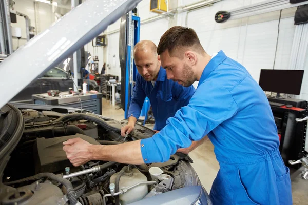 Hombres mecánicos con llave inglesa reparación de coches en el taller — Foto de Stock