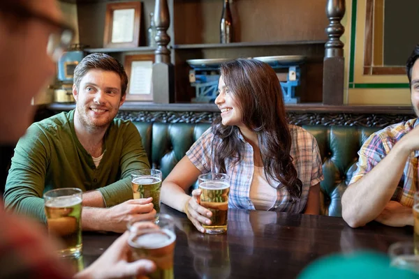 Счастливые друзья пьют пиво в баре или пабе — стоковое фото
