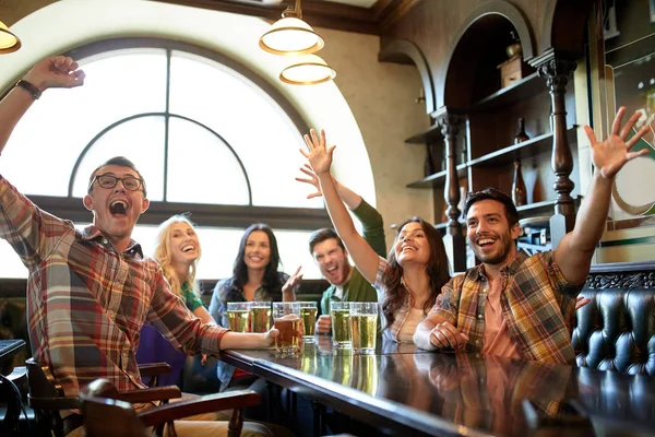 Amigos com cerveja assistindo futebol no bar ou pub — Fotografia de Stock