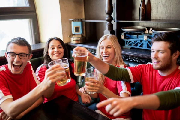 Tifosi di calcio clinking bicchieri di birra allo sport bar — Foto Stock