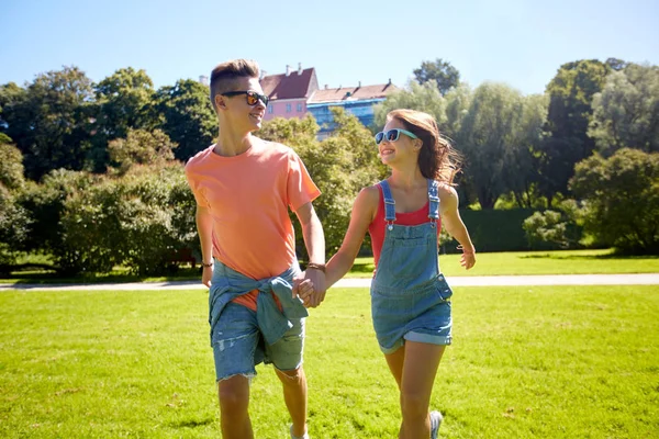 Счастливая пара подростков прогулка в летнем парке — стоковое фото