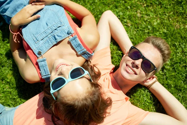 Heureux couple adolescent couché sur l'herbe à l'été — Photo