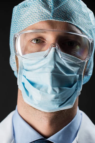 Close up of scientist in goggles, mask and hat — Stock Photo, Image