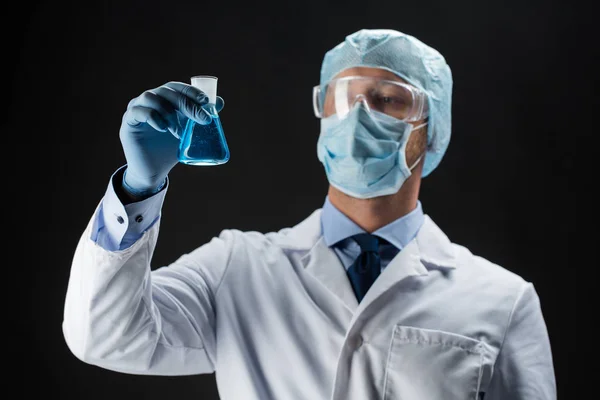 Científico en la máscara que sostiene el frasco con químico —  Fotos de Stock