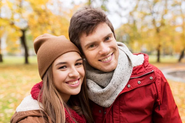 Happy young couple walking in autumn park — Stock Photo, Image
