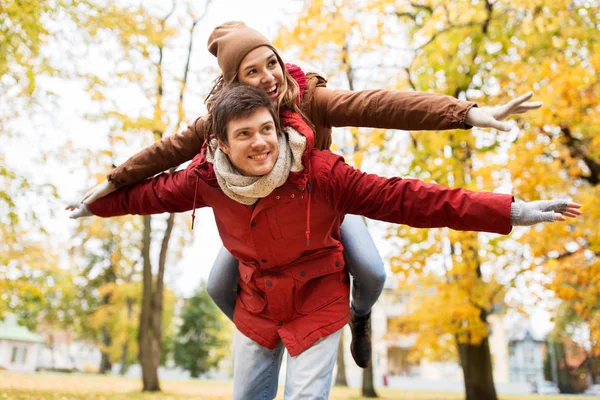 Feliz jovem casal se divertindo no parque de outono — Fotografia de Stock