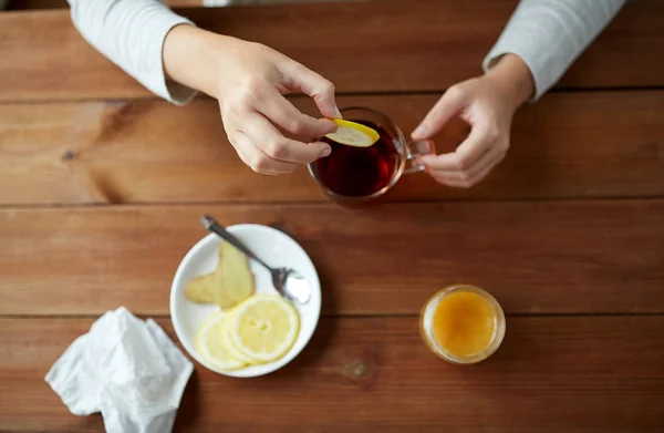 Primer plano de la mujer añadiendo limón a la taza de té — Foto de Stock