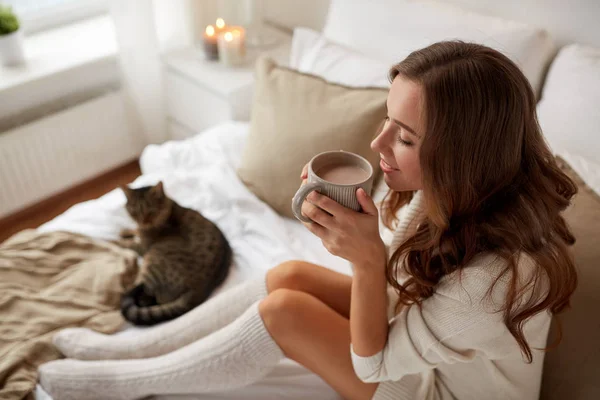 Mujer feliz con taza de café en la cama en casa — Foto de Stock