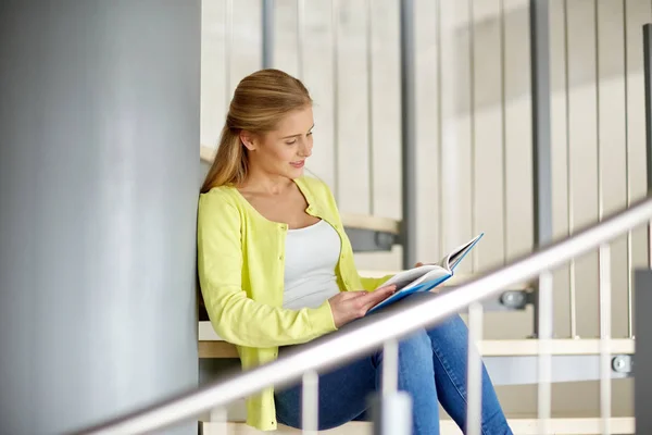 Sonriente estudiante de secundaria chica leyendo libro Fotos de stock