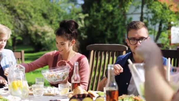 Glückliche Freunde beim Abendessen bei sommerlicher Gartenparty — Stockvideo