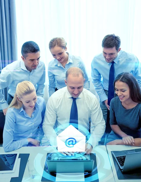 Gente d'affari sorridente con computer portatile in ufficio — Foto Stock