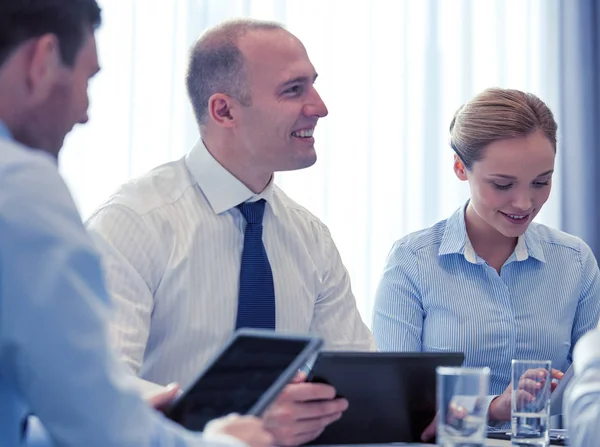 Uomini d'affari sorridenti con tablet pc in ufficio — Foto Stock