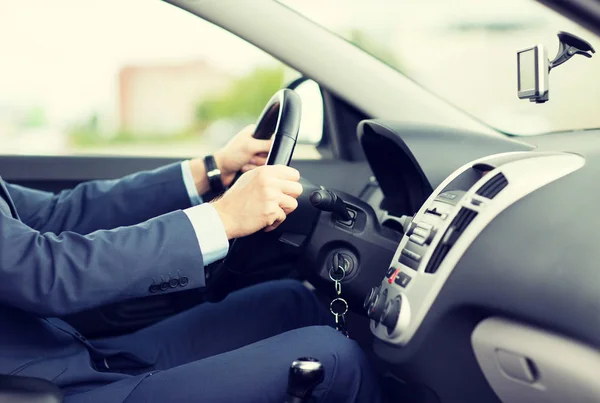 Close up of young man in suit driving car — Stock Photo, Image