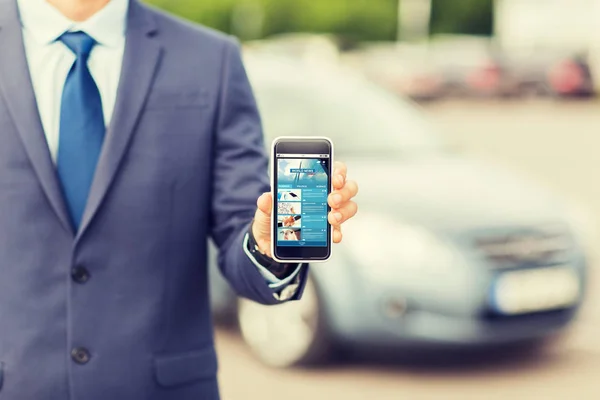 Primer plano de hombre de negocios con teléfono inteligente y coche —  Fotos de Stock
