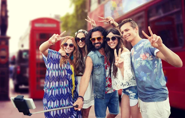 Amigos hippies con smartphone en palo selfie — Foto de Stock