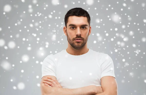 Joven con brazos cruzados sobre fondo de nieve —  Fotos de Stock