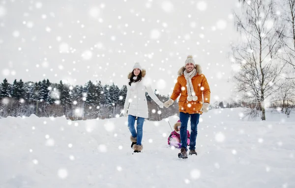 幸福的家庭，与雪橇行走在冬天的户外 — 图库照片