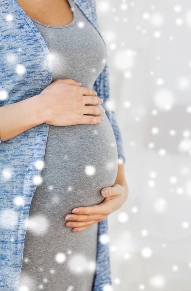 Perto de barriga de mulher grávida e mãos — Fotografia de Stock