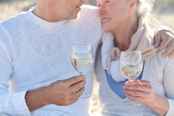 Happy senior couple drinking wine on summer beach — Stock Photo, Image
