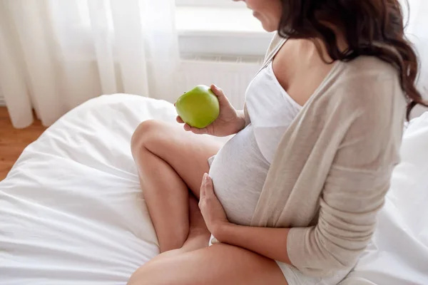 Zamknij się kobieta w ciąży jedzenia jabłek w domu — Zdjęcie stockowe