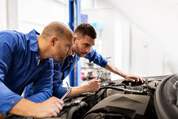 Mecânico homens com chave de reparação de carro na oficina — Fotografia de Stock