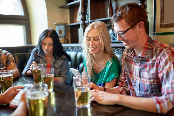 朋友与智能手机和啤酒在酒吧或酒馆 — 图库照片