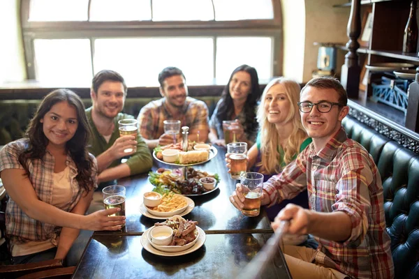 Amigos felizes com vara selfie no bar ou pub — Fotografia de Stock