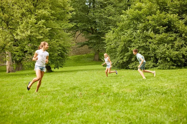 Счастливые дети бегают и играют в игры на открытом воздухе — стоковое фото