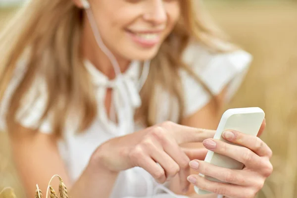 Primo piano della donna con smartphone e auricolari — Foto Stock