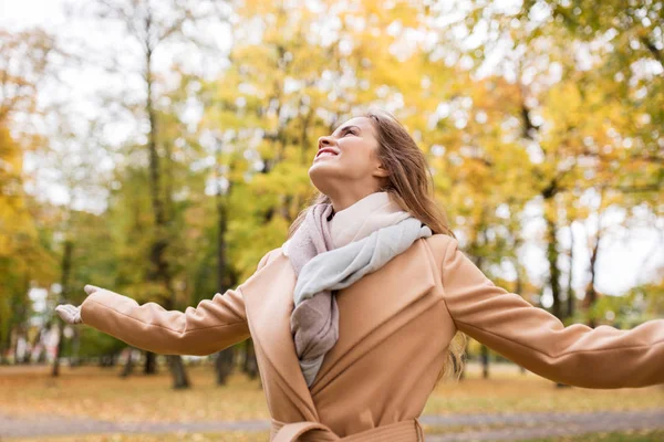 Schöne glückliche junge Frau, die im herbstlichen Park spaziert — Stockfoto