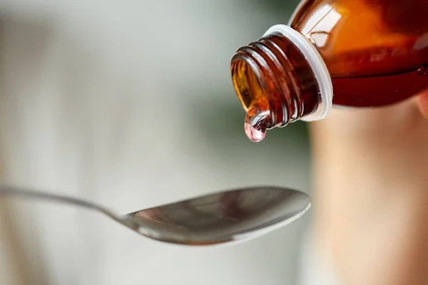 Medication or antipyretic syrup and spoon — Stock Photo, Image