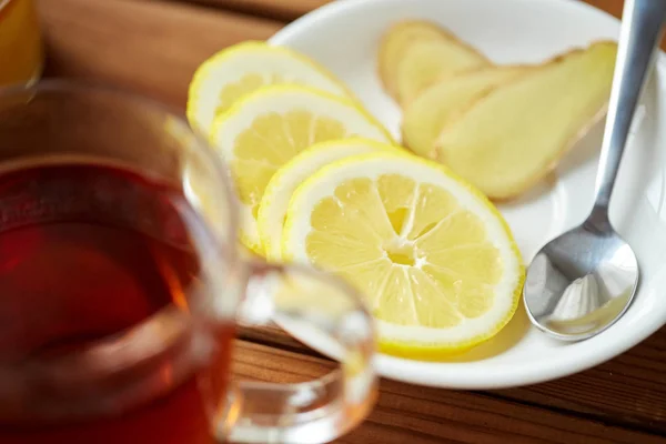 Cangkir teh dengan lemon dan jahe di piring — Stok Foto