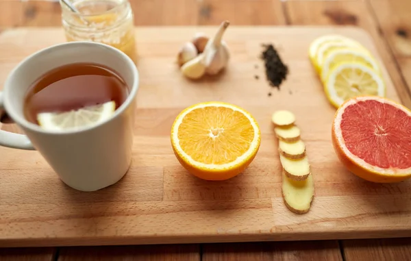Имбирный чай с медом, цитрусовыми и чесноком на дереве — стоковое фото