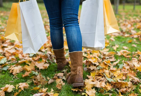 秋の公園を歩いての買い物袋を持つ女性 — ストック写真