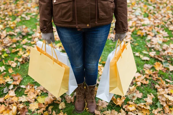 Kobieta z torbami na zakupy w jesiennym parku — Zdjęcie stockowe