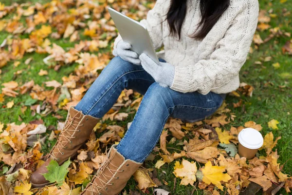 Mujer con tablet PC y café en el parque de otoño —  Fotos de Stock