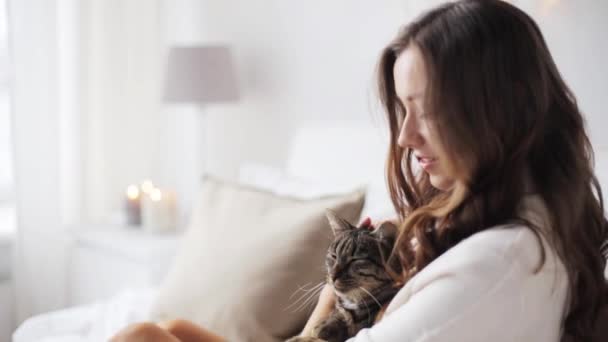 Feliz joven con gato en la cama en casa — Vídeos de Stock