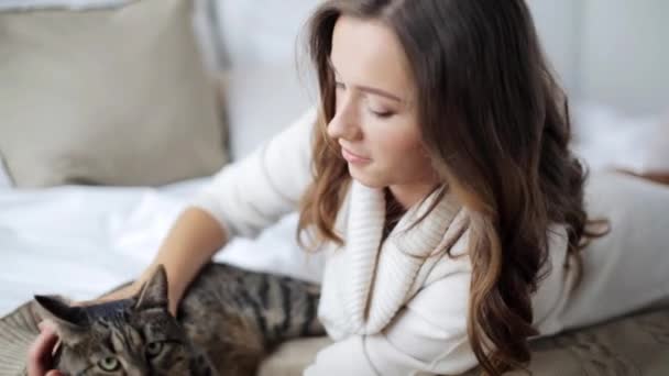 Jovem feliz com gato na cama em casa — Vídeo de Stock
