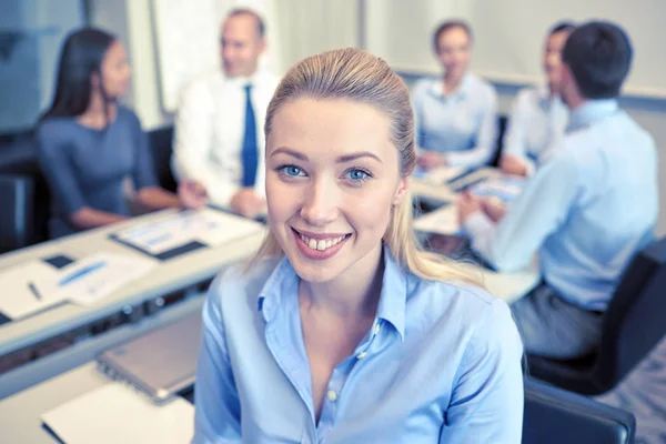 Grupo de empresarios sonrientes reunidos en el cargo — Foto de Stock