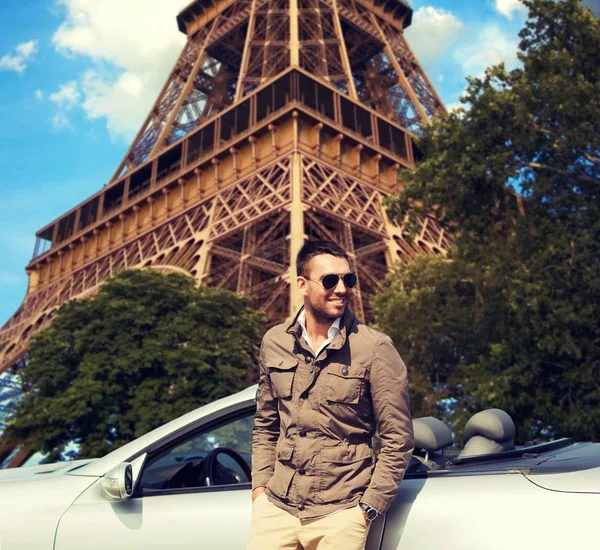 Uomo felice vicino cabriolet auto sopra torre eiffel — Foto Stock