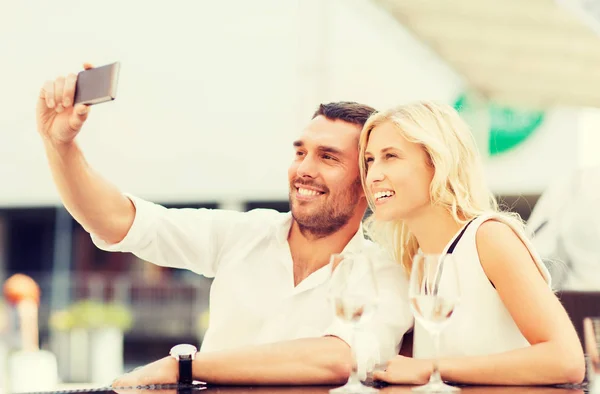 Gelukkige paar nemen selfie met smartphone in café — Stockfoto