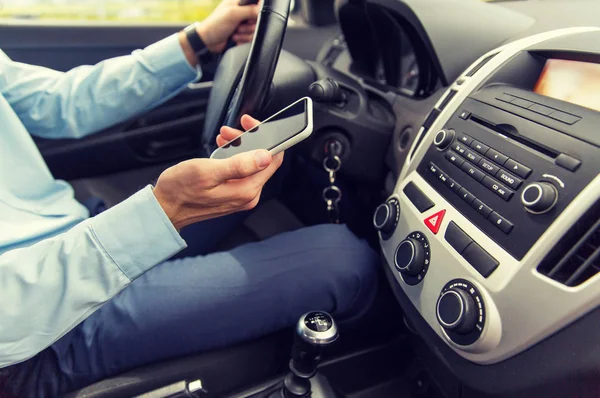 Närbild på mannen med smartphone som kör bil — Stockfoto