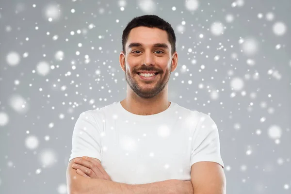 Sorrindo homem com braços cruzados sobre fundo de neve — Fotografia de Stock