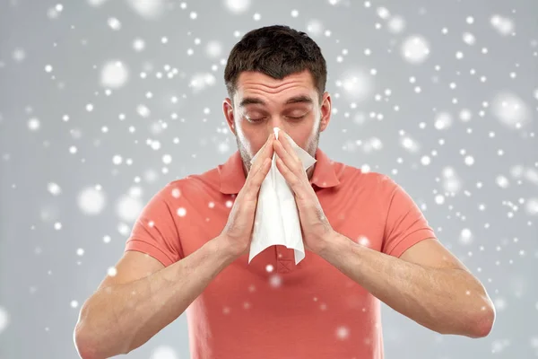Kranker Mann mit Papierwischer weht Nase über Schnee — Stockfoto