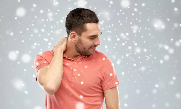 Несчастный человек страдает от боли в шее из-за снега — стоковое фото